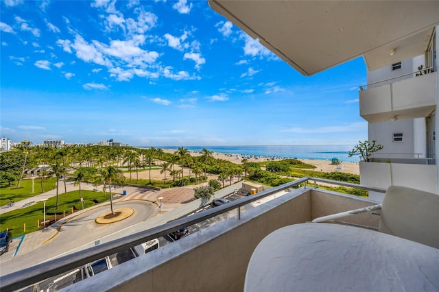 balcony featuring a beach view and a water view