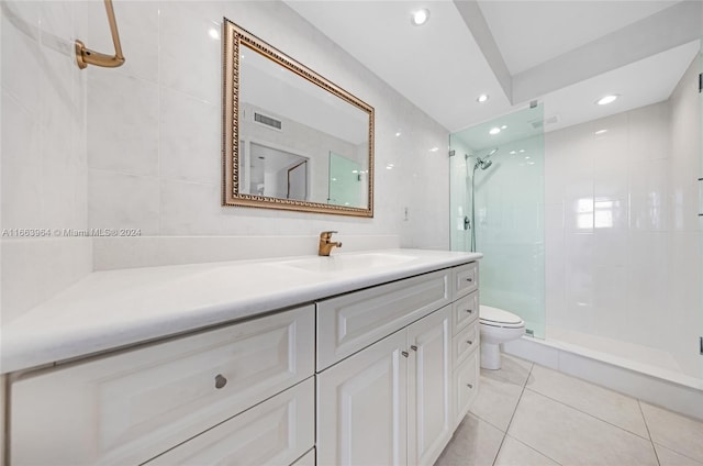 bathroom featuring vanity, toilet, tile patterned floors, and a shower with shower door