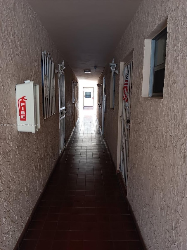 corridor featuring dark tile patterned flooring