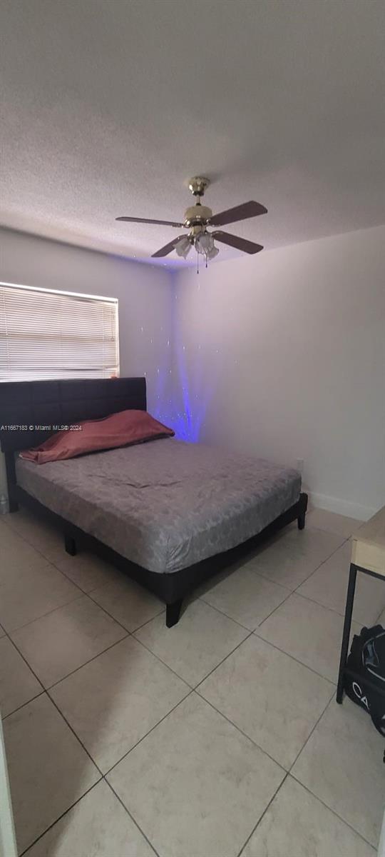 unfurnished bedroom featuring light tile patterned floors and ceiling fan