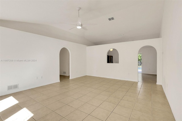 tiled empty room featuring vaulted ceiling and ceiling fan