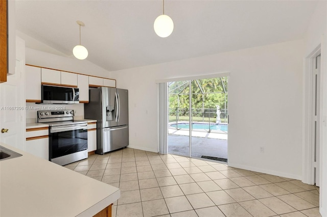 kitchen featuring pendant lighting, white cabinetry, vaulted ceiling, stainless steel appliances, and light tile patterned floors