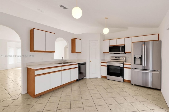 kitchen with white cabinets, lofted ceiling, sink, decorative light fixtures, and stainless steel appliances