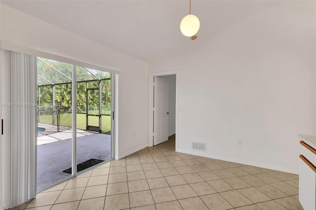 unfurnished room featuring vaulted ceiling and light tile patterned floors