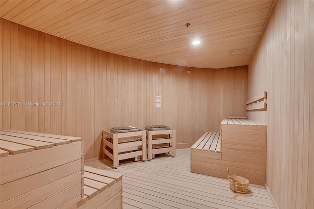 view of sauna / steam room featuring wood-type flooring, wooden ceiling, and wooden walls