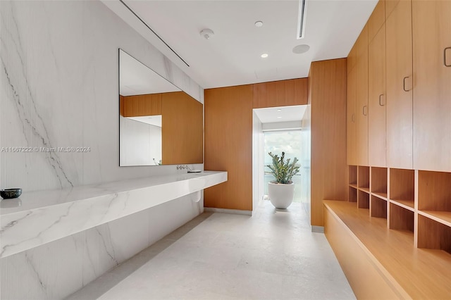 bathroom featuring a bathtub and wooden walls