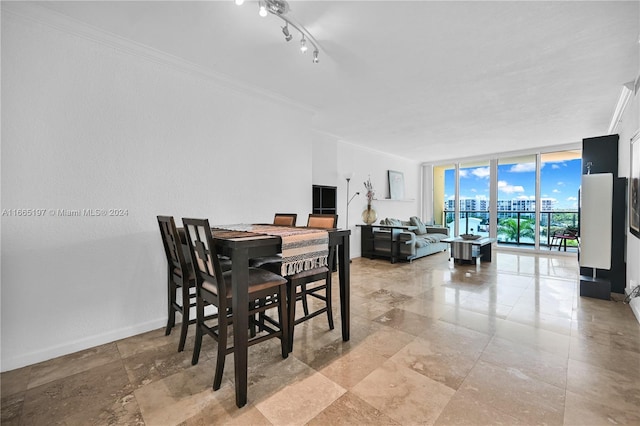 dining space with a wall of windows, crown molding, and rail lighting