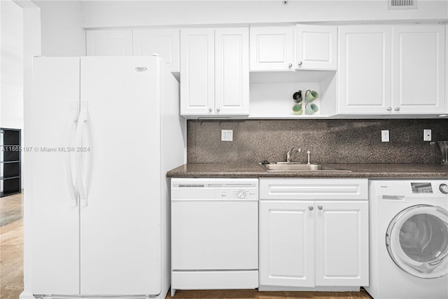 kitchen with white appliances, white cabinets, washer / clothes dryer, and sink