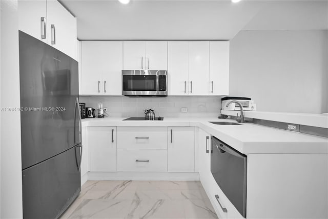 kitchen featuring white cabinets, black appliances, sink, and backsplash