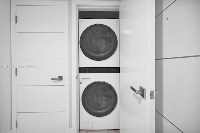 washroom with stacked washing maching and dryer