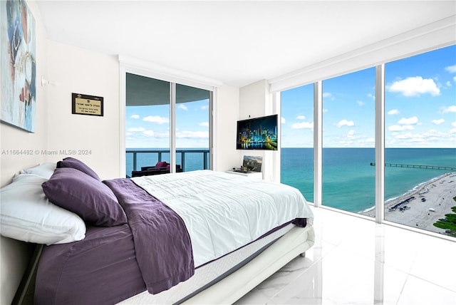 tiled bedroom featuring a wall of windows and access to outside