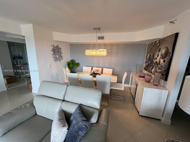 tiled living room with a notable chandelier