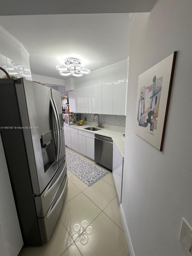 kitchen with sink, white cabinets, stainless steel appliances, backsplash, and light tile patterned floors