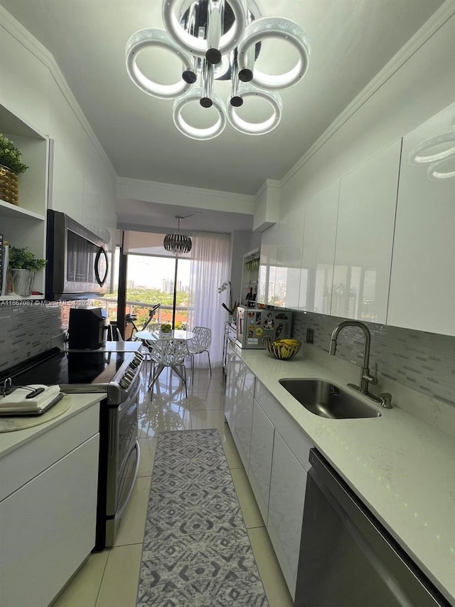 kitchen featuring light tile patterned flooring, sink, tasteful backsplash, white cabinetry, and appliances with stainless steel finishes