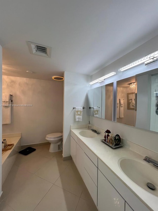 bathroom with tile patterned floors, a bath, vanity, and toilet