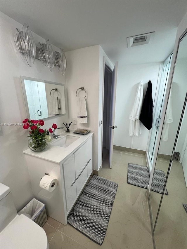 bathroom with vanity, toilet, an enclosed shower, and tile patterned floors