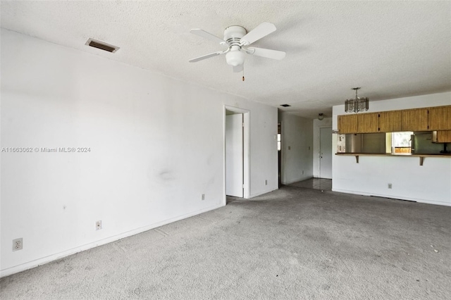 unfurnished living room with ceiling fan, a textured ceiling, and carpet flooring