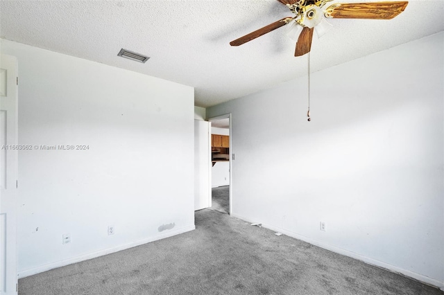 carpeted empty room with a textured ceiling and ceiling fan