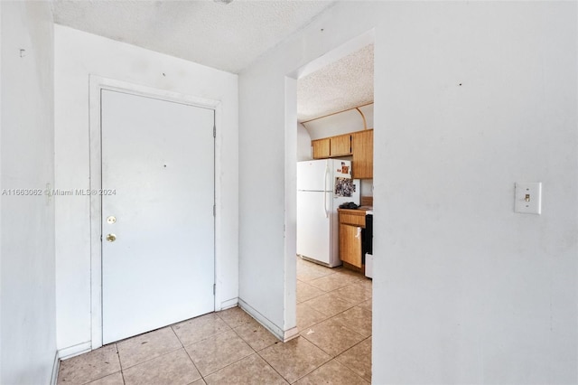 interior space with a textured ceiling and light tile patterned floors