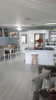 kitchen featuring ceiling fan, hardwood / wood-style flooring, and stainless steel refrigerator