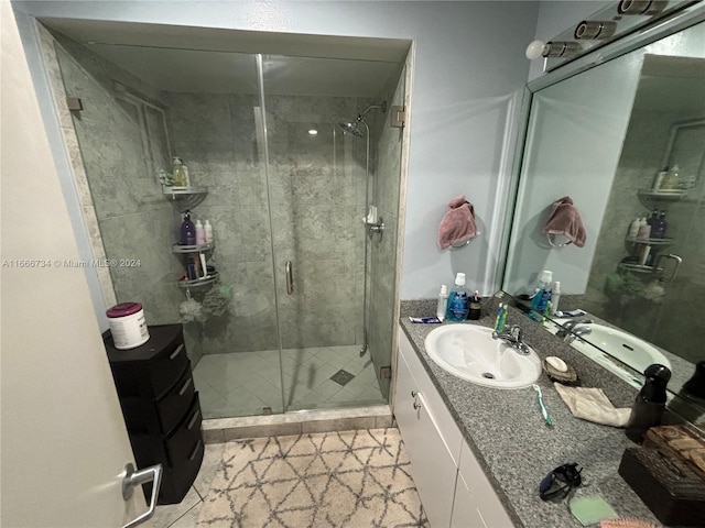 bathroom with a shower with door, tile patterned floors, and vanity