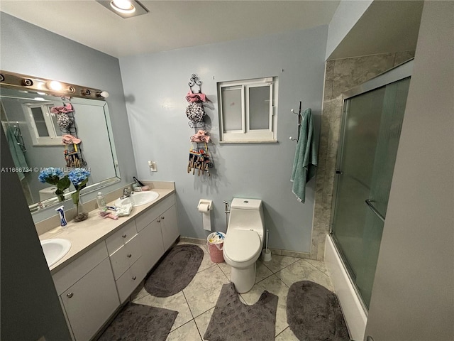 full bathroom featuring tile patterned floors, vanity, bath / shower combo with glass door, and toilet