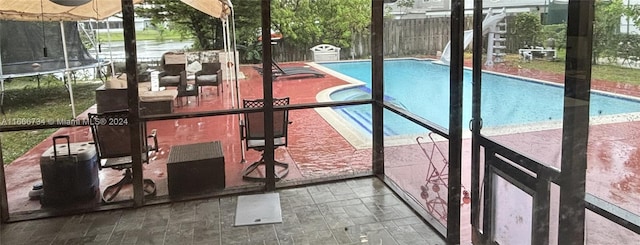 view of swimming pool featuring a trampoline and a patio area