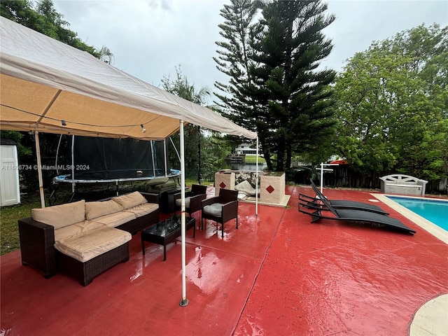 view of patio with an outdoor hangout area, a shed, and a trampoline