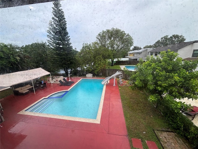 view of swimming pool featuring a patio and a water slide