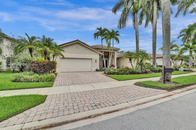 ranch-style home featuring a garage and a front lawn