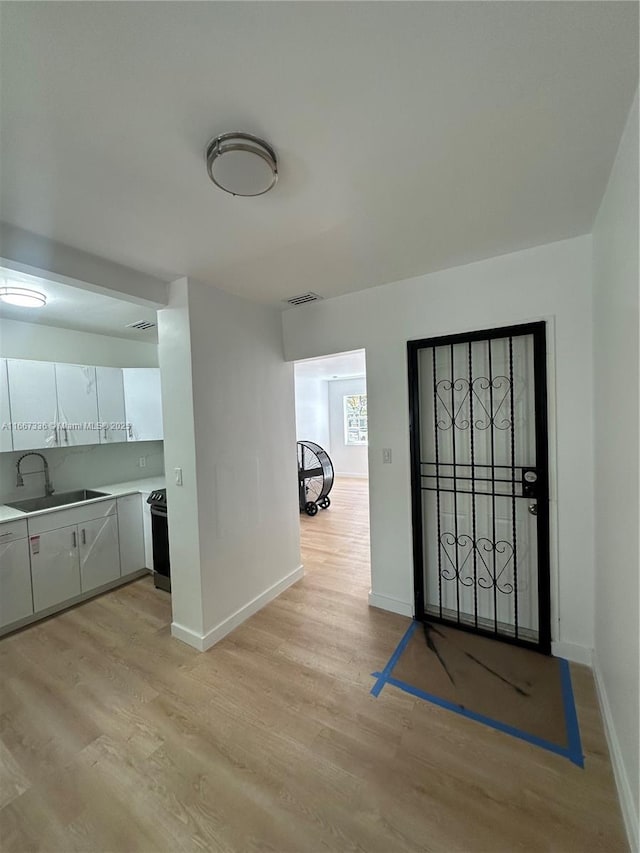 entryway featuring light wood finished floors, visible vents, and baseboards