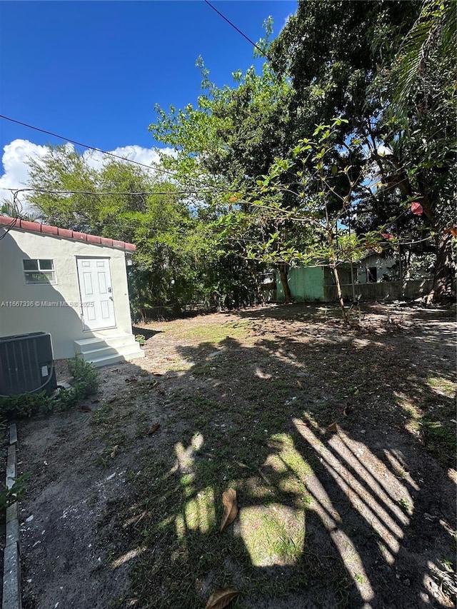 view of yard with entry steps and central air condition unit