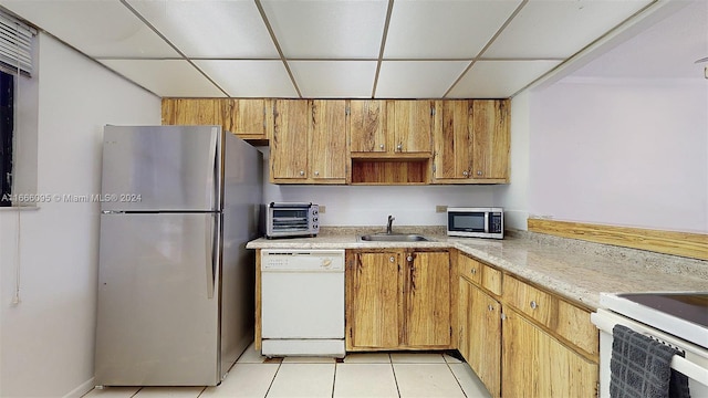 kitchen featuring sink, stainless steel appliances, a drop ceiling, and light tile patterned flooring