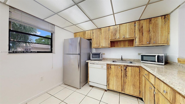 kitchen featuring appliances with stainless steel finishes, a paneled ceiling, sink, and light tile patterned floors