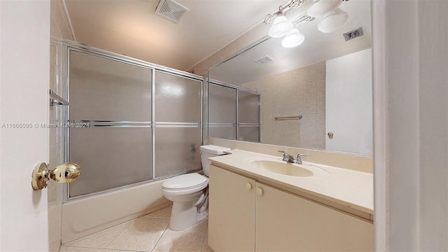 full bathroom with bath / shower combo with glass door, vanity, toilet, and tile patterned floors