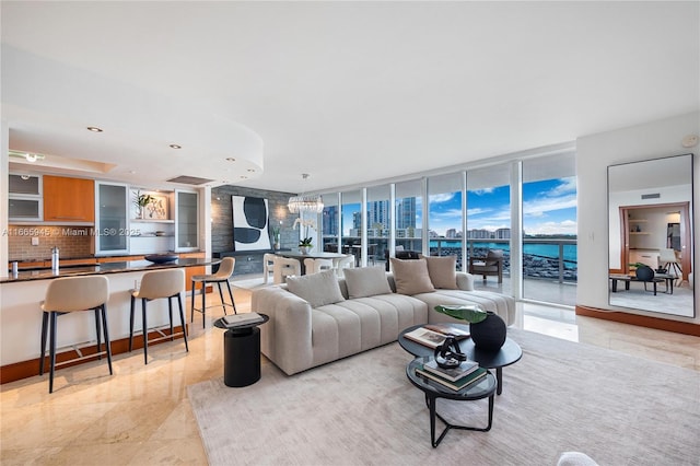 living room with expansive windows, a water view, and sink