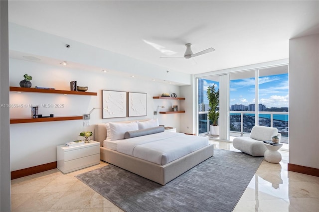 bedroom with expansive windows, a water view, ceiling fan, and access to outside