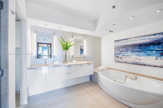 bathroom with a tub to relax in, tile patterned floors, and vanity