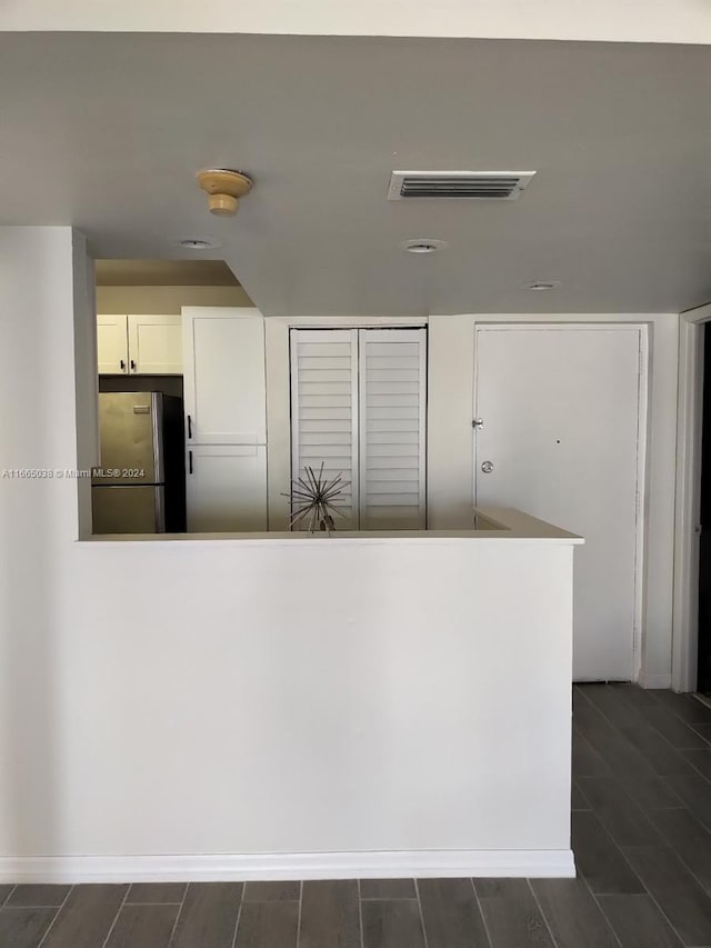 kitchen with white cabinets, stainless steel fridge, and dark hardwood / wood-style flooring