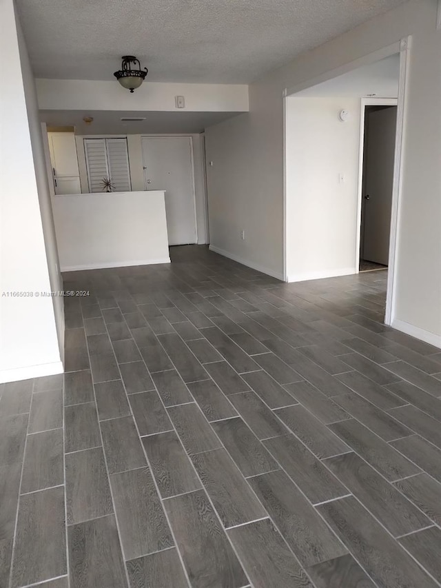 spare room featuring dark hardwood / wood-style floors and a textured ceiling