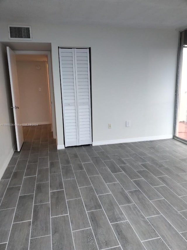 unfurnished bedroom featuring multiple windows and dark wood-type flooring