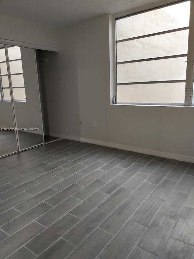 unfurnished bedroom featuring dark hardwood / wood-style flooring and a closet