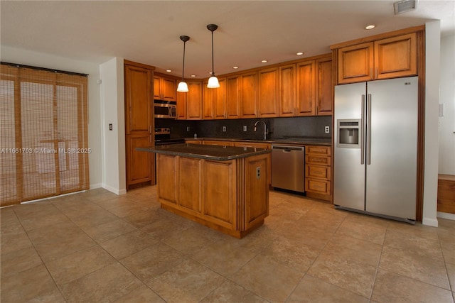 kitchen with tasteful backsplash, appliances with stainless steel finishes, brown cabinetry, and a sink