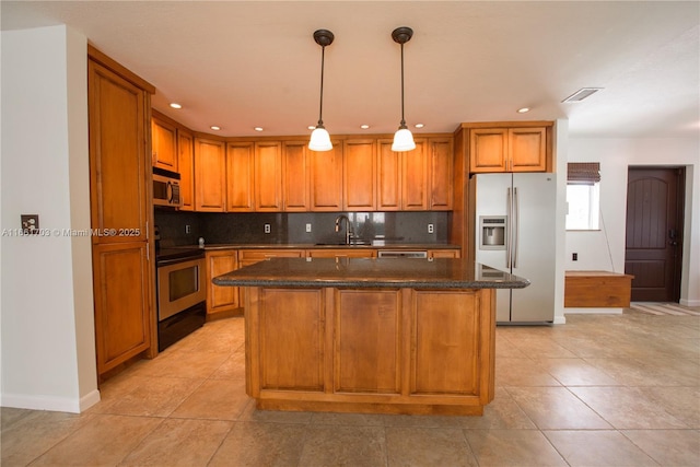 kitchen featuring stainless steel appliances, a sink, visible vents, and brown cabinets