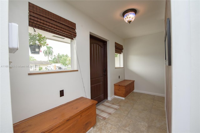 foyer entrance featuring baseboards and light tile patterned flooring