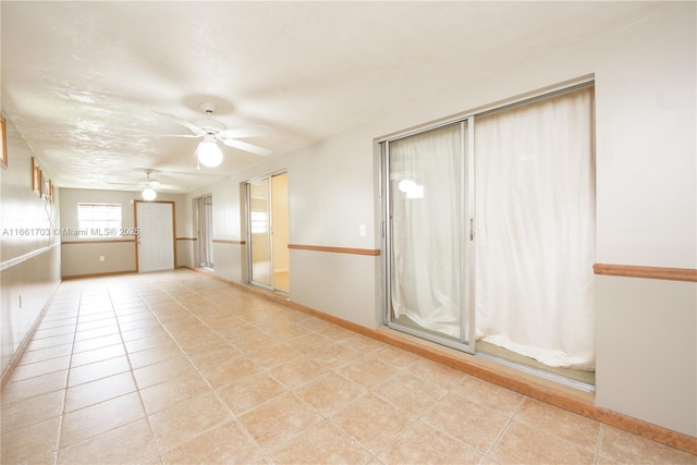 unfurnished room with light tile patterned floors, ceiling fan, and baseboards