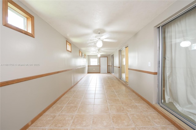 hallway featuring light tile patterned flooring and baseboards