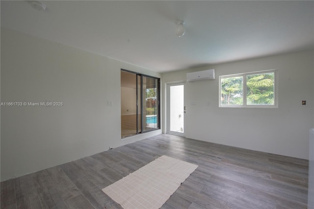 empty room with a wall unit AC and wood finished floors