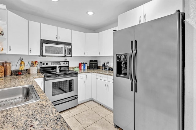 kitchen featuring stainless steel appliances, white cabinets, and light tile patterned floors