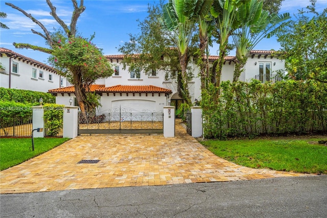 mediterranean / spanish home featuring a front yard and a garage